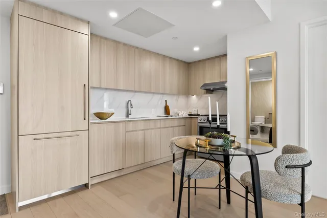 a kitchen with a refrigerator and white cabinets