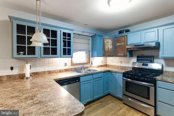 a kitchen with granite countertop a sink and a stove