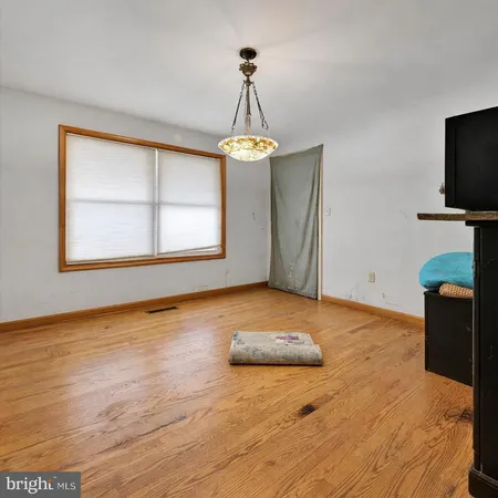 a view of a livingroom with wooden floor and workspace