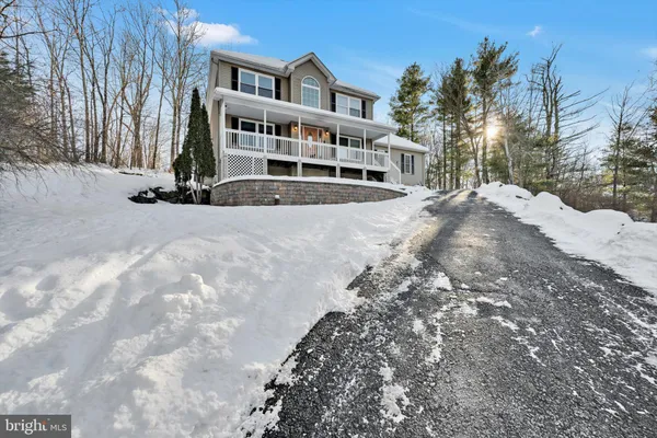 a view of a white house with a yard covered in snow