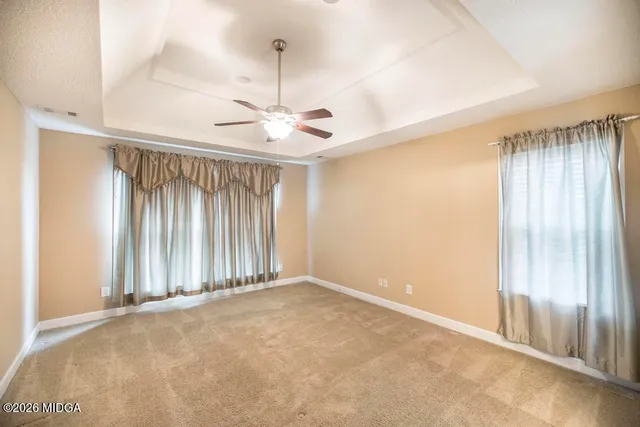 an empty room with fan and windows