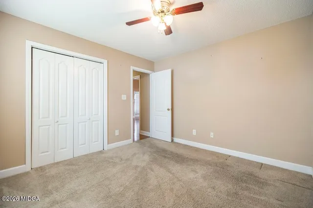 an empty room with chandelier fan