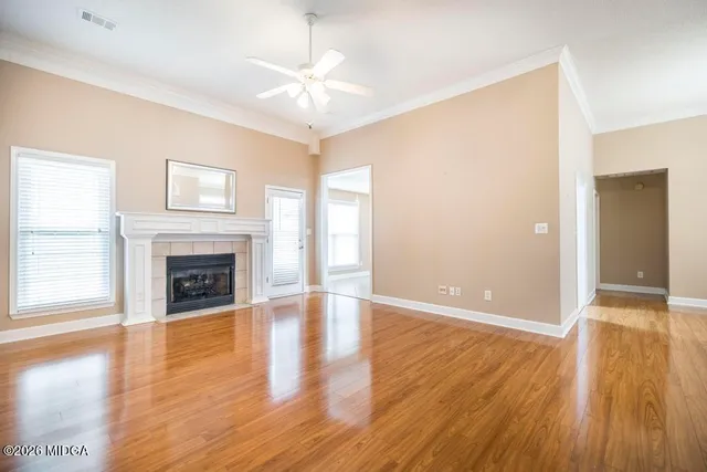 a view of a livingroom with wooden floor and a fireplace