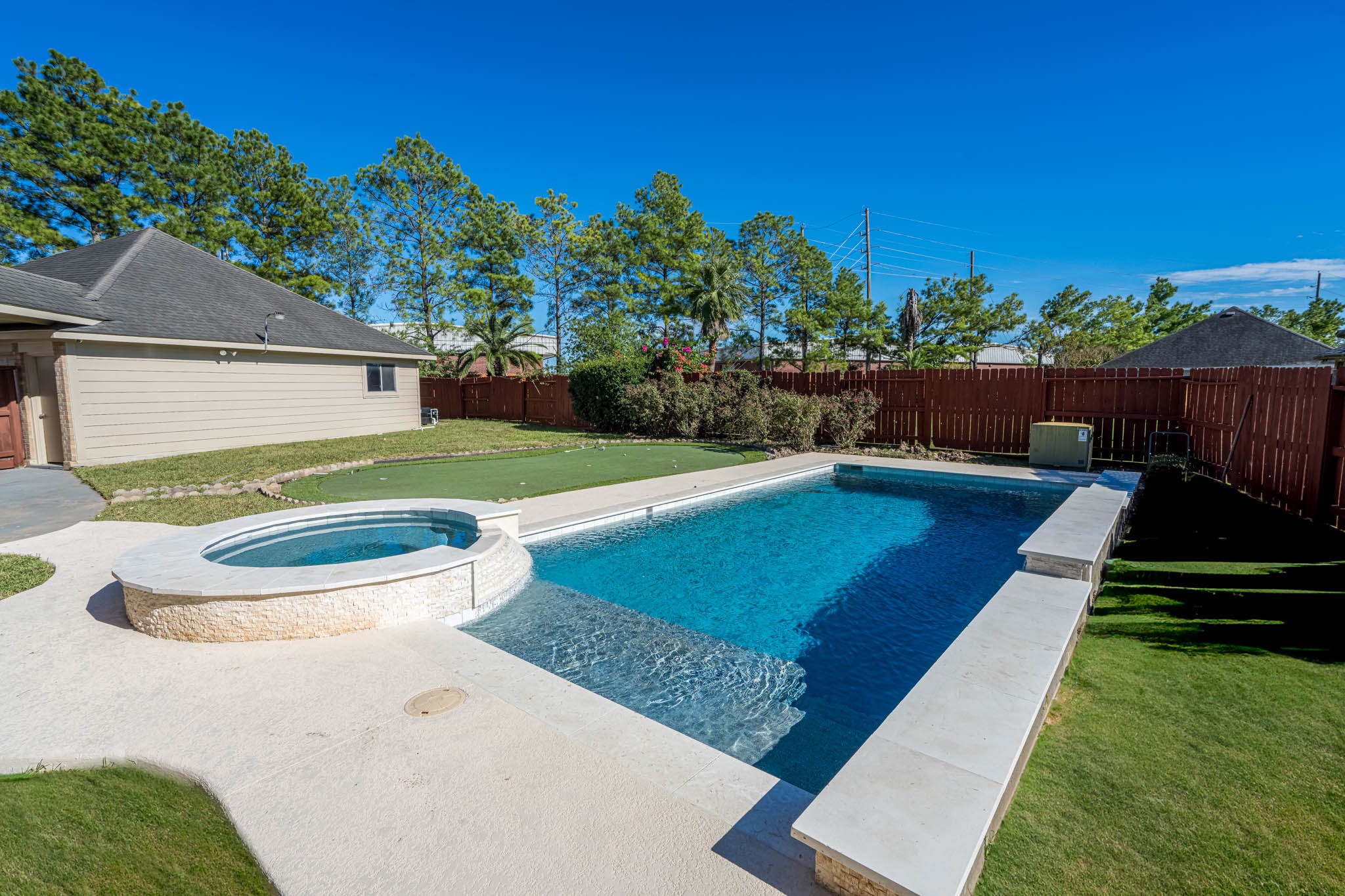 6506 Monte Bello Ridge Lane Houston, TX 77041 - Photo 18 of 39 This backyard features a spacious in-ground pool with an attached spa, surrounded by lush green lawn and a privacy fence, perfect for relaxation and entertaining.