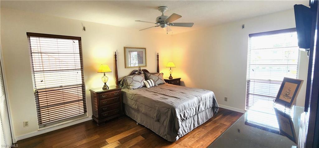 102 Georgetown Boulevard, Unit 102 Naples, FL 34112 - Photo 14 of 29 a bedroom with a bed and a chandelier