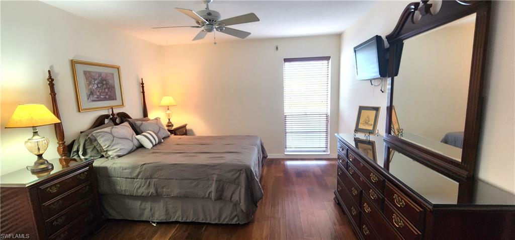 102 Georgetown Boulevard, Unit 102 Naples, FL 34112 - Photo 15 of 29 a bedroom with a bed and a lamp on the dresser