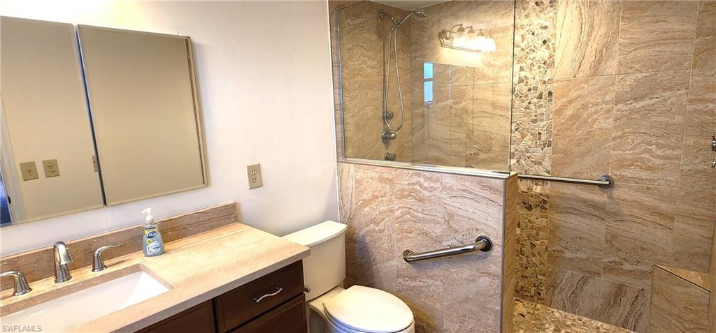 102 Georgetown Boulevard, Unit 102 Naples, FL 34112 - Photo 16 of 29 a bathroom with a granite countertop sink toilet and shower