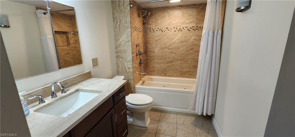 102 Georgetown Boulevard, Unit 102 Naples, FL 34112 - Photo 19 of 29 a bathroom with a sink a toilet a mirror and shower