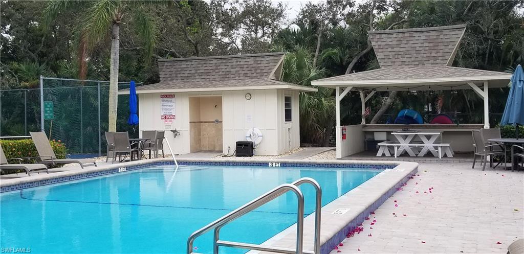 102 Georgetown Boulevard, Unit 102 Naples, FL 34112 - Photo 23 of 29 a view of a house with pool and chairs