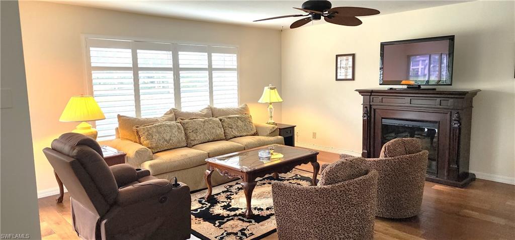 102 Georgetown Boulevard, Unit 102 Naples, FL 34112 - Photo 5 of 29 a living room with furniture and a fireplace