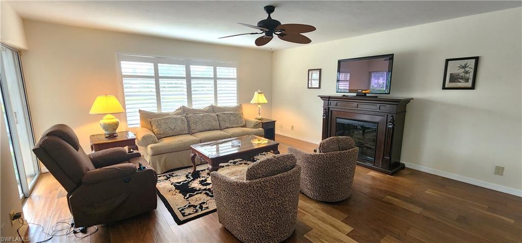 102 Georgetown Boulevard, Unit 102 Naples, FL 34112 - Photo 6 of 29 a living room with furniture a chandelier and a window