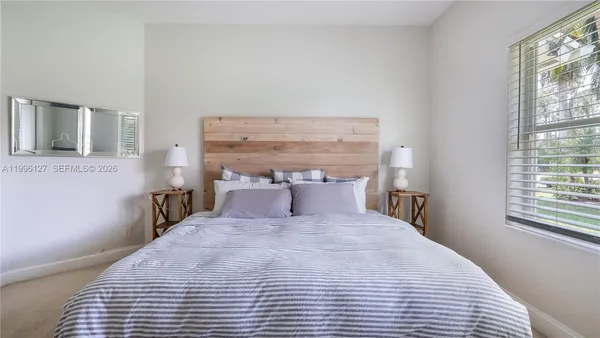a large bed sitting in a bedroom next to a window
