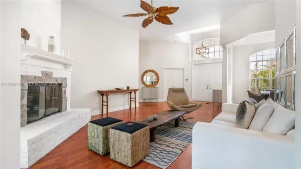a living room with furniture a window and wooden floor