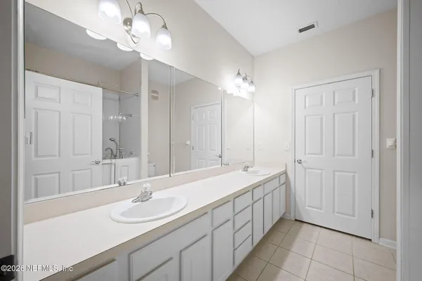 a bathroom with a double vanity sink and a mirror