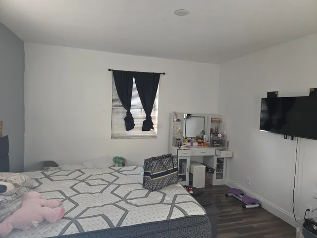 a living room with a bed furniture and a flat screen tv