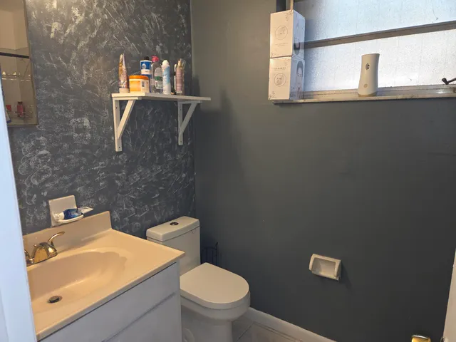 a bathroom with a toilet a sink and mirror