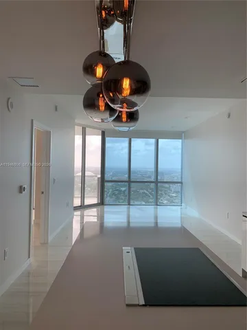a living room with furniture a fireplace and a floor to ceiling window