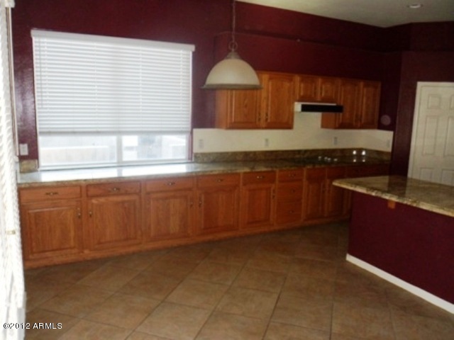3469 East Cabazon Court Gilbert, AZ 85297 - Photo 6 of 25 a kitchen with granite countertop a stove a sink and a microwave