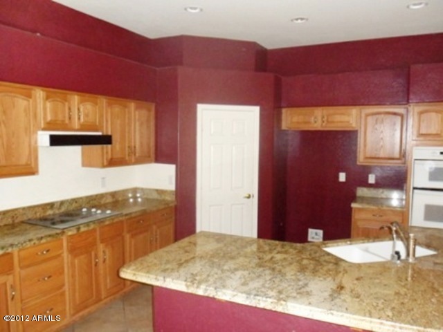 3469 East Cabazon Court Gilbert, AZ 85297 - Photo 8 of 25 a kitchen with granite countertop sink and cabinets