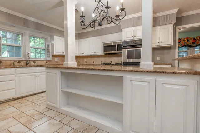 a kitchen with stainless steel appliances granite countertop a sink and cabinets