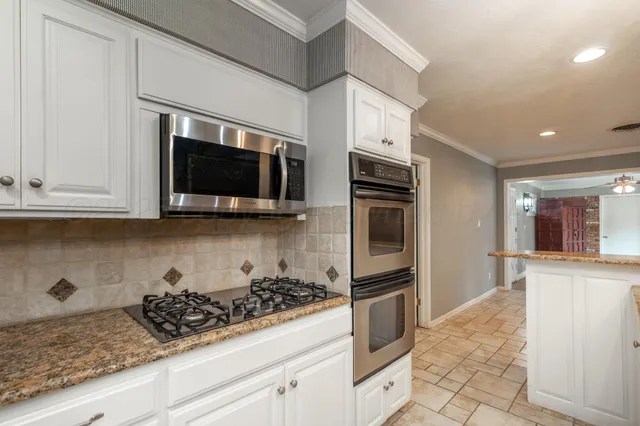 a kitchen with stainless steel appliances granite countertop a sink stove and microwave