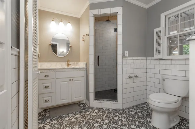 a bathroom with a granite countertop toilet sink and mirror