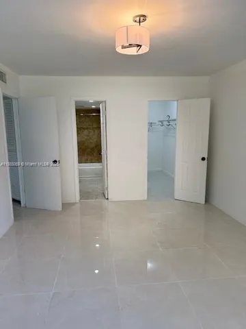 an empty room with closet and windows