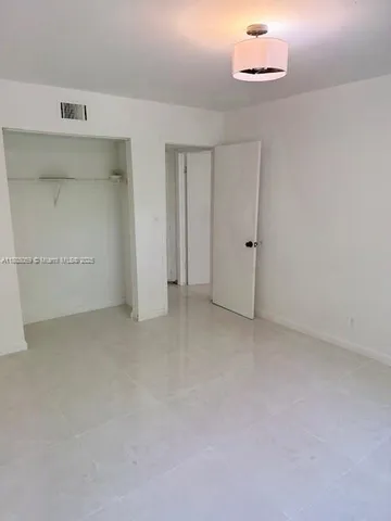 an empty room with a cabinet and mirrors