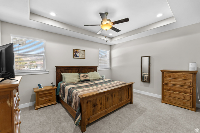 3678 Spiral Springs Road, Unit 204 Tooele, UT 84074 - Photo 25 of 59 Tray ceiling with recessed lighting, ceiling fan with integrated light, two windows with blinds, and light gray carpet flooring