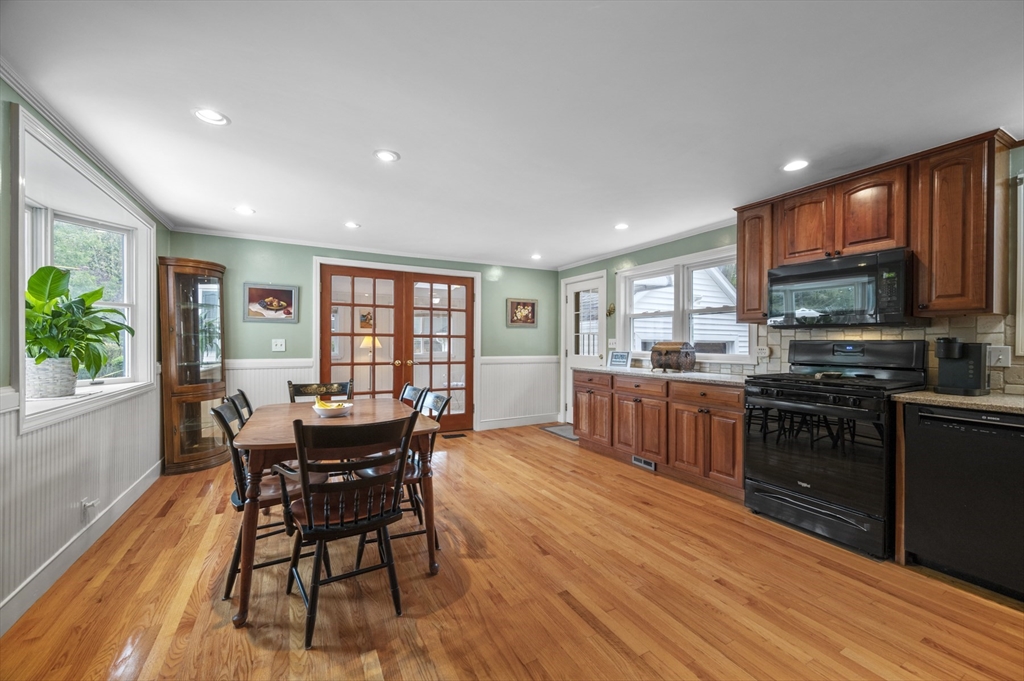 14 Arnold Road Peabody, MA 01960 - Photo 8 of 36 a kitchen with stainless steel appliances kitchen island granite countertop a stove top oven a sink a dining table and chairs with wooden floor