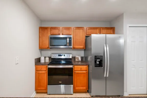 a kitchen with stainless steel appliances granite countertop a refrigerator a stove and a microwave