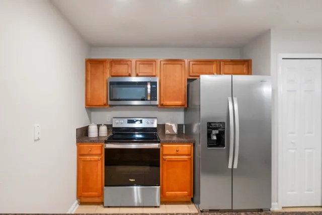 a kitchen with stainless steel appliances granite countertop a refrigerator a stove and a microwave