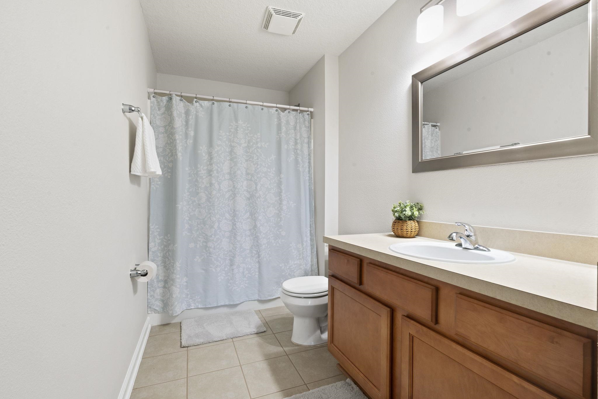 2441 Golden Lake Loop St. Augustine, FL 32084 - Photo 26 of 34 a bathroom with a sink a toilet and shower curtain