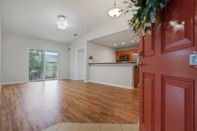 a view of a livingroom with wooden floor and a large window