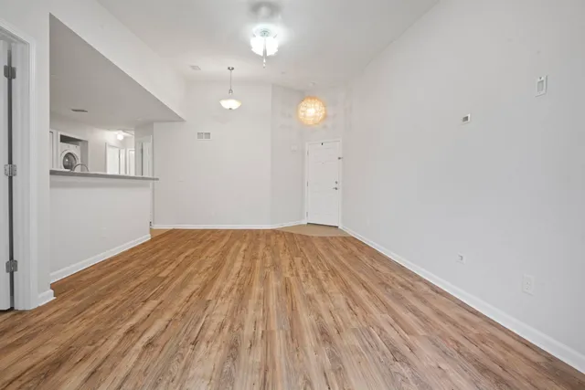 a view of empty room with wooden floor