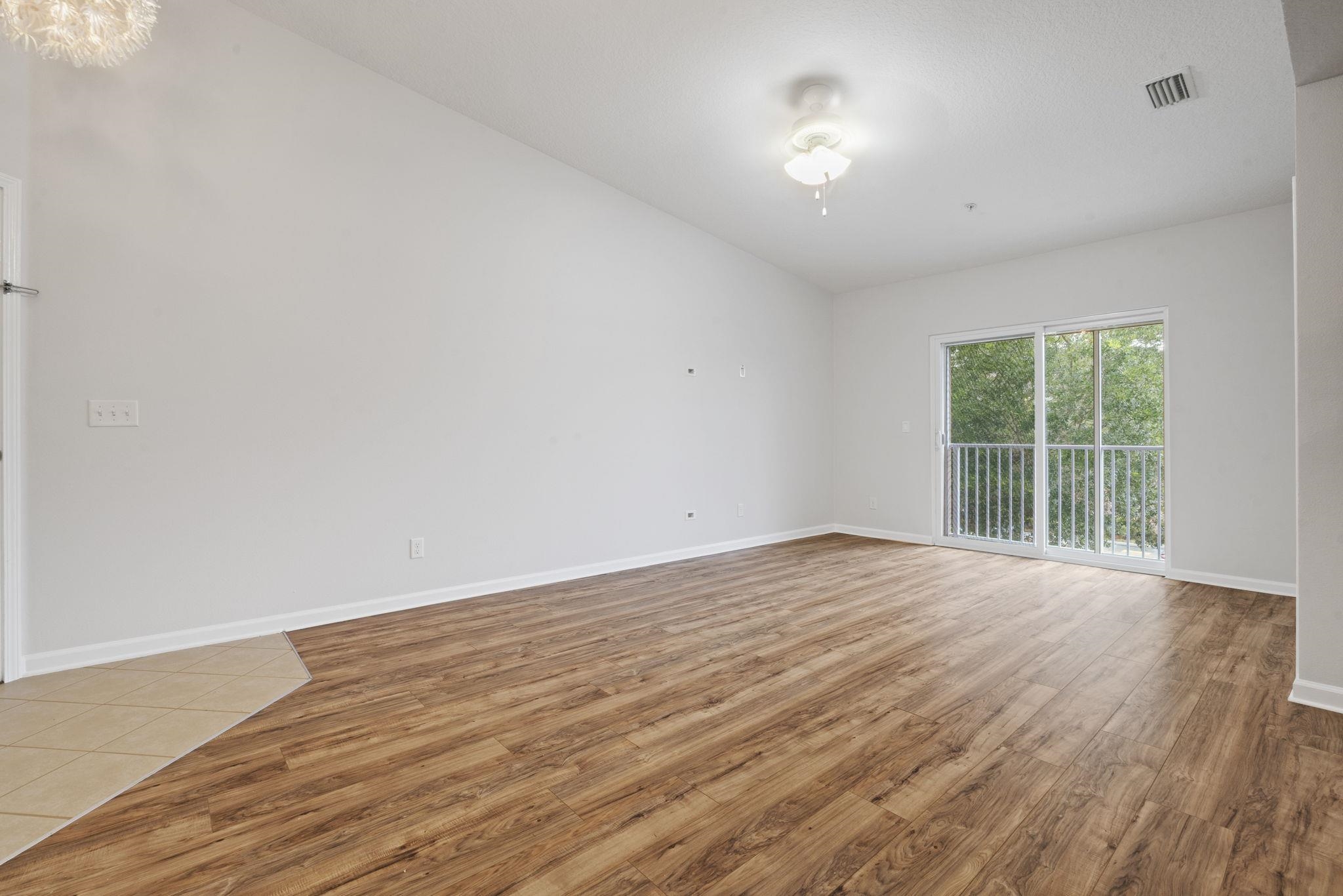 2441 Golden Lake Loop St. Augustine, FL 32084 - Photo 7 of 34 a view of an empty room with wooden floor and a window