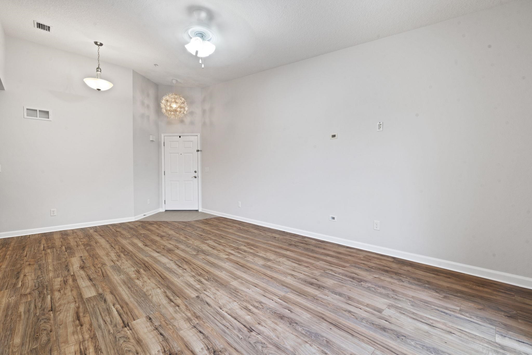 2441 Golden Lake Loop St. Augustine, FL 32084 - Photo 10 of 34 an empty room with wooden floor and fan