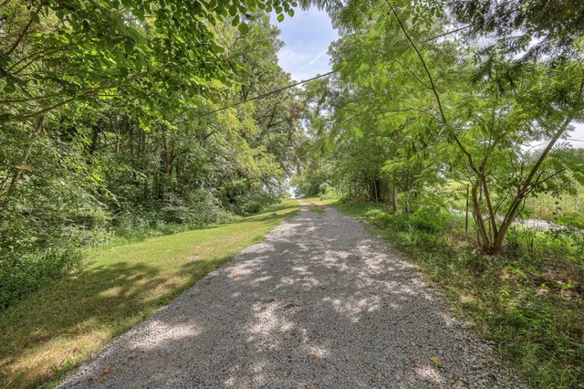 an empty room with wooden floor cabinet and windows