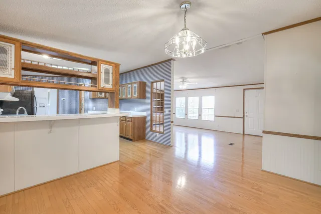 an empty room with wooden floor and balcony