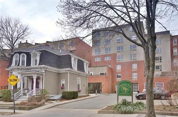 66 Winchester Street, Unit 401 Brookline, MA 02446 - Photo 1 of 5 a front view of a residential apartment building with a yard