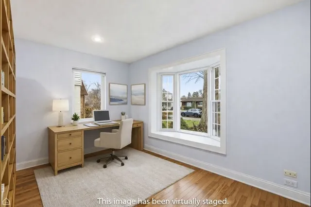 a view of a workspace with furniture and a window