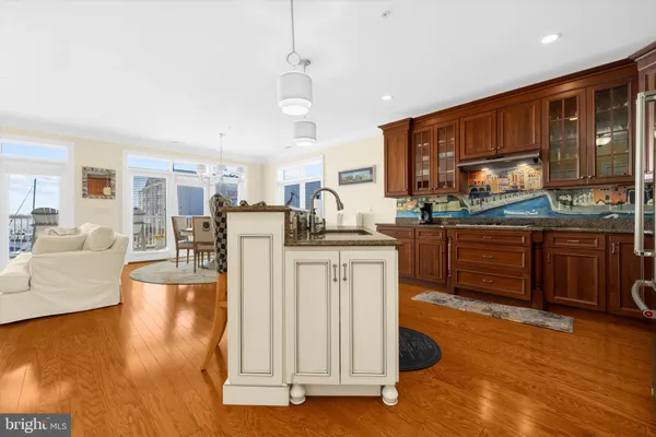 a kitchen with stainless steel appliances granite countertop wooden floors and white cabinets