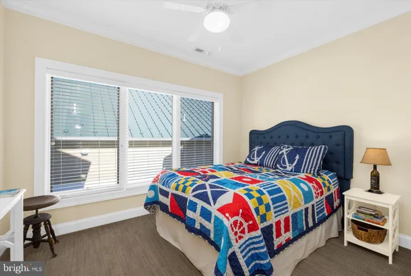 a bedroom with a bed and a lamp on the dresser