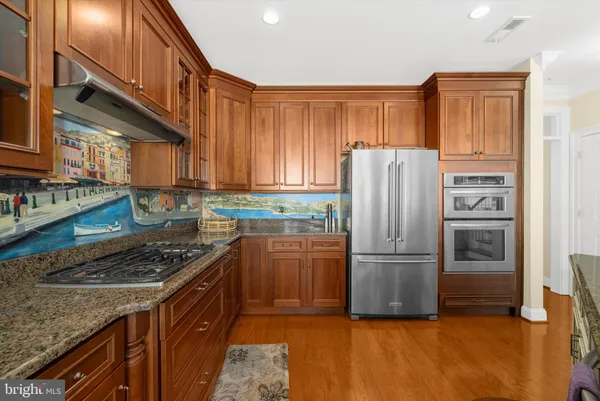 a kitchen with granite countertop stainless steel appliances and wooden cabinets