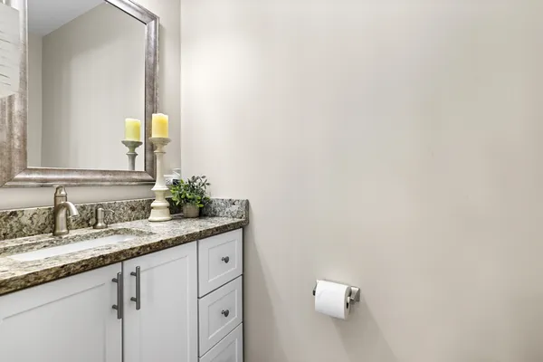 a bathroom with a granite countertop sink and a mirror