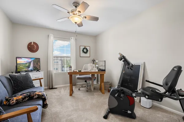 a view of a workspace with furniture and a window