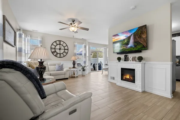 a living room with furniture a flat screen tv and a fireplace
