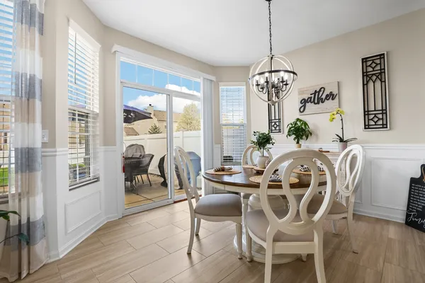 a dining room with furniture a chandelier and wooden floor