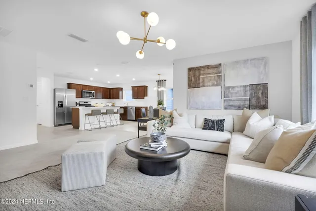 a living room with furniture and a chandelier