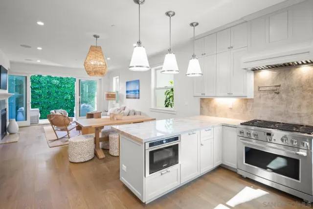 a open kitchen with stainless steel appliances granite countertop a stove a sink and a wooden floors